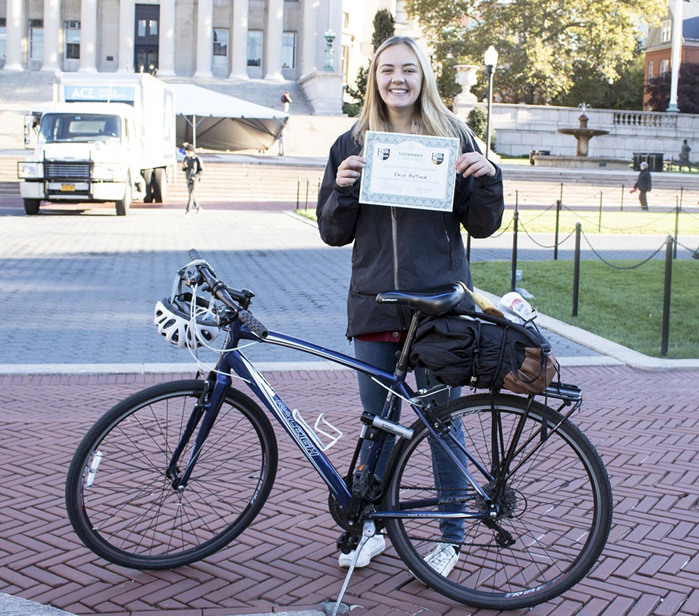 Emily Boytinck poses with her bike and her Sustainable Commuter award at the 2018 Bike Recognition Breakfast on College Walk
